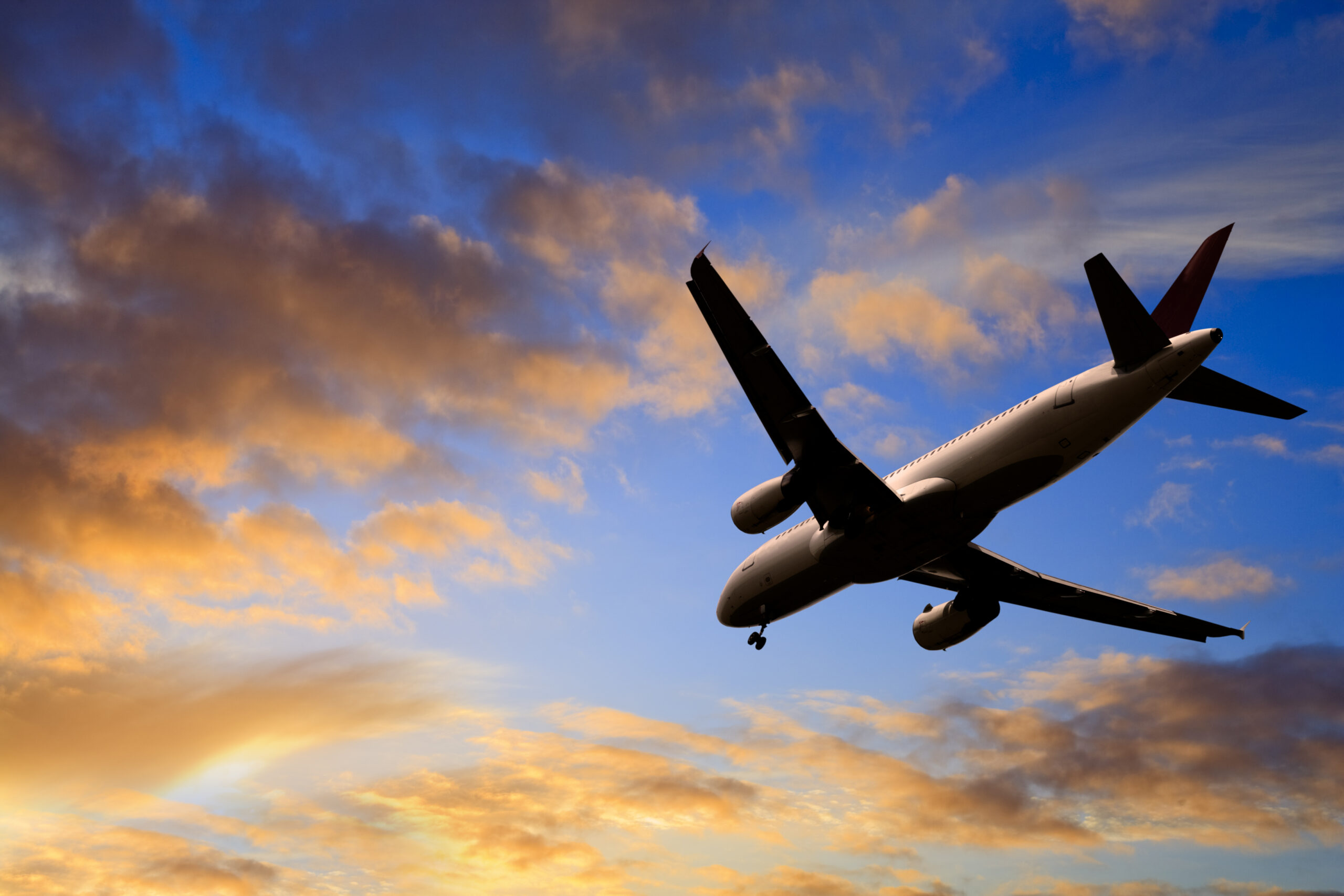 Jet Aeroplane Landing from Bright Sunset Sky Blue Orange Horizon
